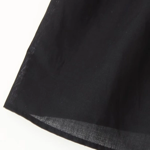 Close-up of black embroidered V-neck sleeveless blouse fabric with light texture
