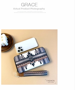 Detailed view of long zip-around wallet with ethnic pattern and detachable wristlet strap