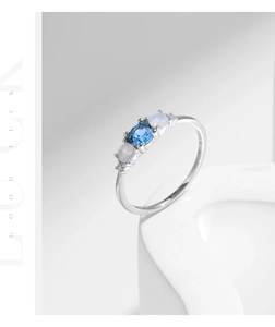Macro shot of S925 sterling silver ring with blue gemstone and white opal details