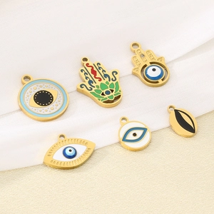 Detailed flat lay of 18K gold-plated stainless steel Hamsa and Evil Eye charms