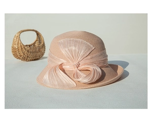 Vue détaillée du chapeau de paille rose avec nœud en soie élégant et perles décoratives