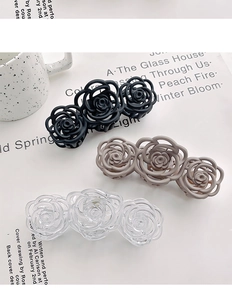 Three hollow camellia flower hair claws in black, beige, and clear resin finishes