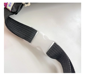 Detail of adjustable black nylon strap with white plastic buckle on sequin bag