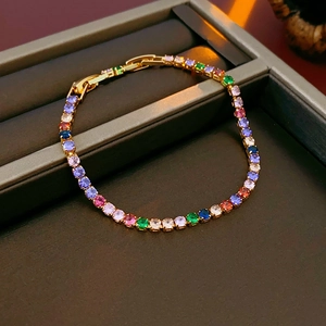 Close-up of gold plated tennis bracelet with colorful round zircons in a jewelry box