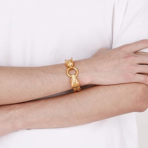 Detail of gold titanium steel double wolf head bracelet with ring clasp on male model
