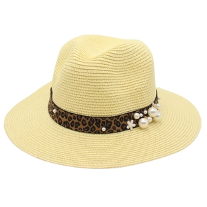 Close-up of beige panama hat with leopard print ribbon and elegant pearl flower accents