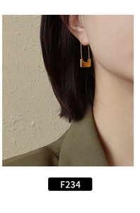 Close-up of minimalist gold U-shaped earring on model for modern style look