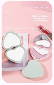 Detail of heart-shaped folding pocket mirror in mint green and pale pink matte finish