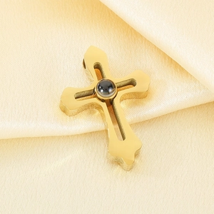 Detailed view of gold stainless steel cross pendant with central projection stone on silk