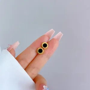 Macro detail of gold-plated titanium steel studs with roman numerals and black enamel