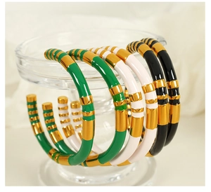 Detail of vintage enamel bangles in green, white and black on a glass display
