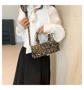 Detail of leopard print baguette bag with structured faux leather and detachable strap
