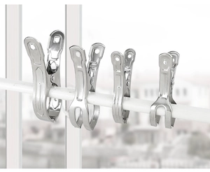 Four different sizes of large stainless steel clips hanging on a white rack with city view