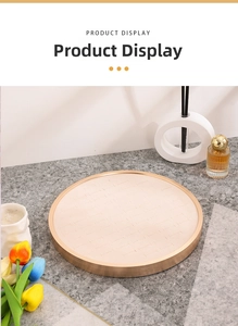 Detail of round beige velvet jewelry tray with gold metal frame on a stone surface