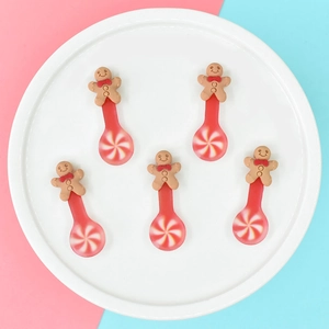 Detailed view of five gingerbread man spoons with red and white swirl patterns