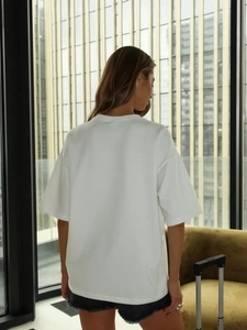 Vista posteriore di una t-shirt bianca oversize in cotone con spalle scese urbana