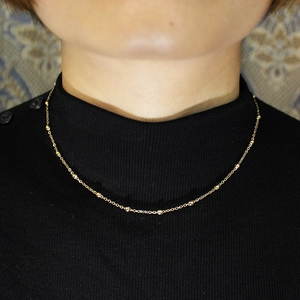 Minimalist gold beaded necklace for women made of waterproof stainless steel on model