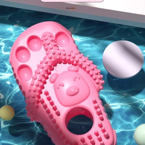 Detail of pink dog chew toy with slipper shape featuring massage texture and cartoon bear