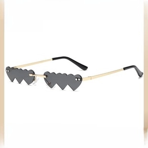 Detail of grey heart-shaped rimless lenses and gold metal temples for Y2K style sunglasses