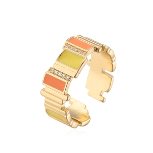 Detail of 18K gold ring featuring orange yellow enamel blocks and white zircon accents