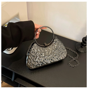 Dettaglio della trama in metallo martellato e del manico tondo della pochette grigio scuro