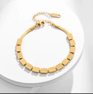 Macro detail of gold-plated titanium steel square link bracelet with LOVE engraving