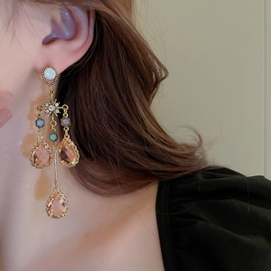 Close-up of vintage gold tassel earrings with champagne crystals on model