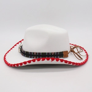 Detail of white felt cowboy hat with red stitching and ethnic woven band with leather tassel