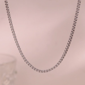 Detailed close-up of a silver stainless steel box chain necklace with a minimalist design