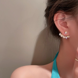 Close-up of elegant gold crescent heart earrings with sparkling cubic zirconia on model
