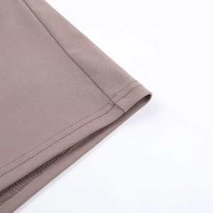 Close-up of double-stitched hem and fine knit texture on coffee-colored dress