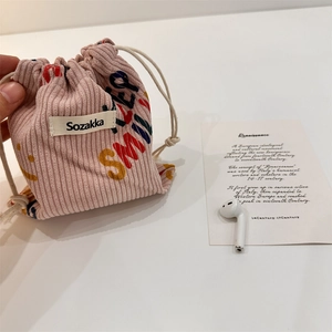 Dettaglio della borsa in velluto a coste rosa con lettere colorate e consistenza morbida