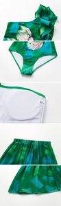Detail view of one-shoulder ruffle and butterfly print fabric of the swimsuit