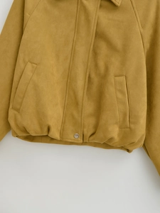 Detail der senfgelben Bomberjacke aus Wildlederimitat mit Stoffstruktur und Tasche