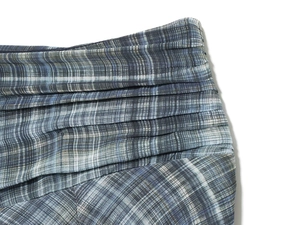 Gros plan sur le tissu à carreaux bleu-gris avec volants superposés et plis fins