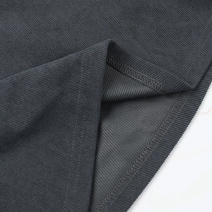 Macro detail of dark grey ribbed knit fabric showing fine texture and sewing craftsmanship