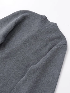 Detailed macro texture of a dark grey knit coat with premium wool blend finish