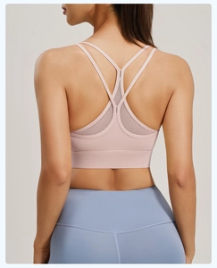 Close-up of pink sports bra featuring cross-back Y-straps and breathable mesh panel
