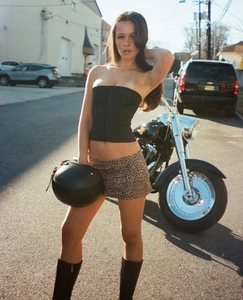 Nahaufnahme des Minirocks mit Leopardenmuster, schwarzen Stiefeln und Bustier