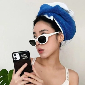 Stylish white cat-eye sunglasses with black lenses worn by a model in a bright setting