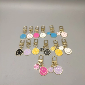 Detail shot of colorful enamel smiley face keychains with polished gold-tone hardware