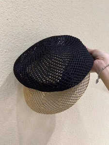 Detailed close-up of summer breathable hollow mesh knit texture of the black beret