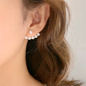 Detail of elegant pearl earring with curved gold base on model side profile