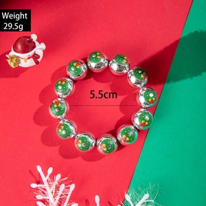 Detailed view of silver resin beads with green wreath prints on a Christmas bracelet