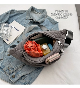 Detailed view of the grey quilted crossbody bag showing spacious interior with personal items