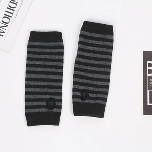 Close-up of black and grey striped knitted arm warmers with thumb holes on white background