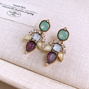 Detail of vintage flower earrings with multicolor gemstones and sparkling crystals