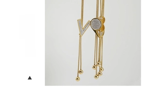 Dettaglio della collana lunga placcata oro 18K con ciondolo a V e nappine sottili