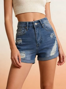 Close-up of high-waisted distressed denim shorts with ripped details and cuffed hems