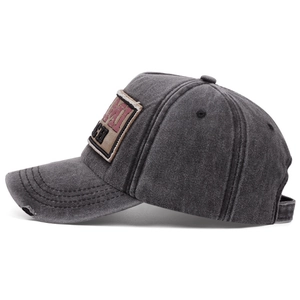 Detailed side view of distressed charcoal grey washed cotton baseball cap with patch